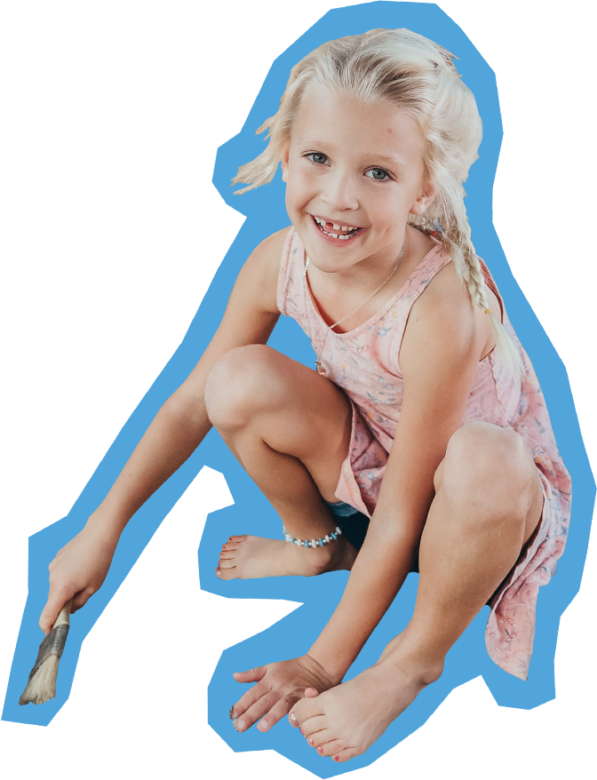 small girl with blonde braid squatting while painting and smiling