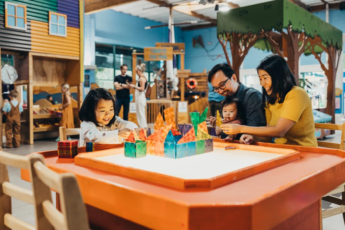 Family playing with plastic blocks on table