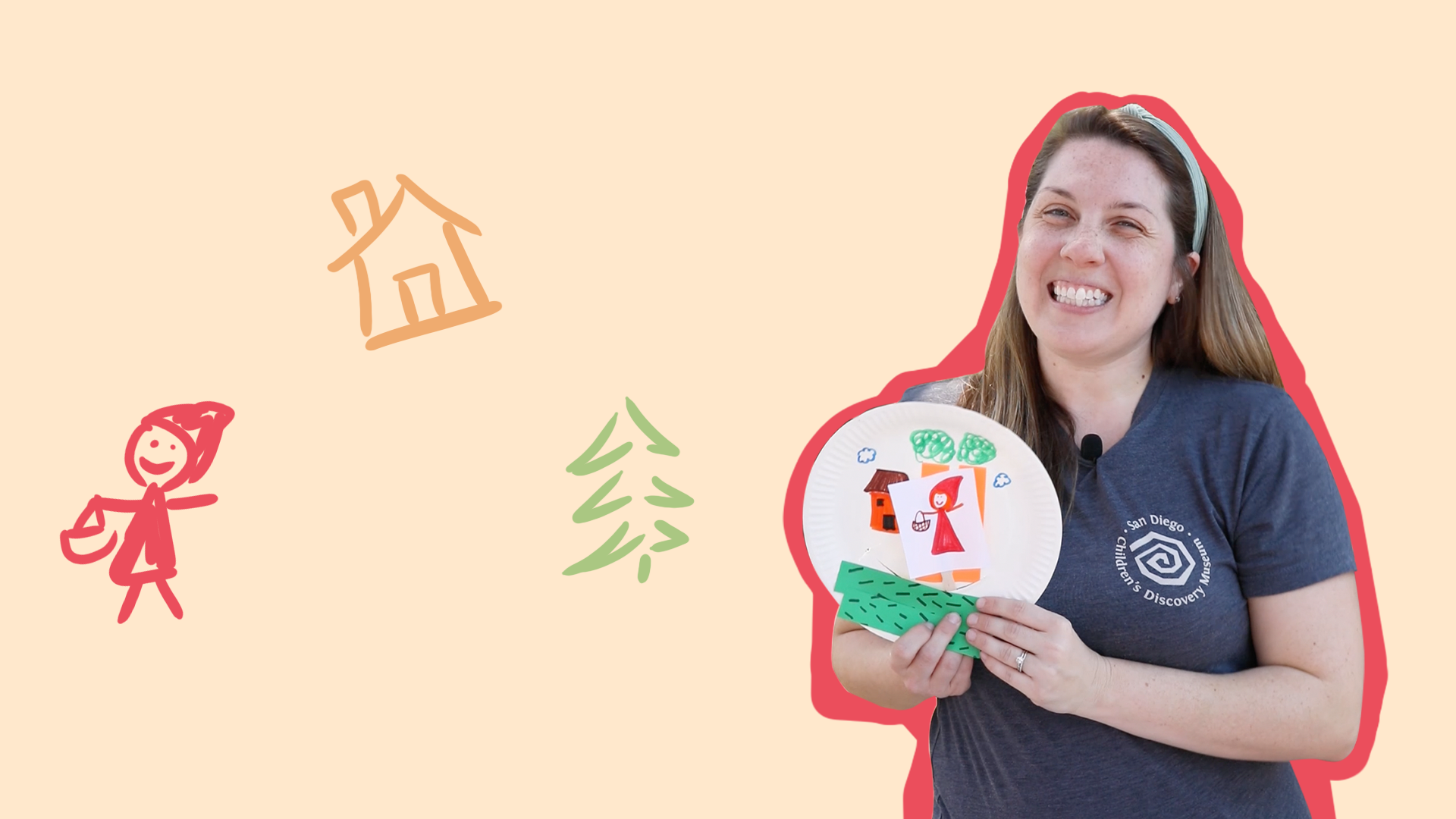 An educator holding a paper plate puppet theater.