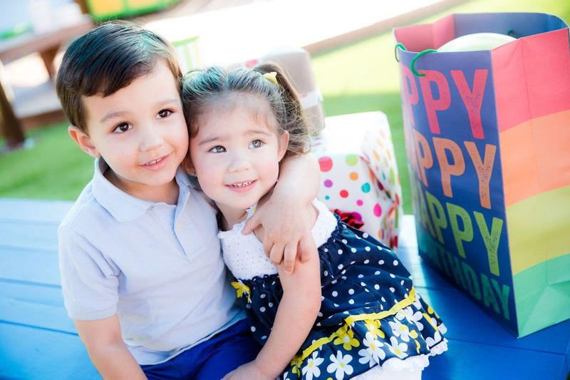 2 kids at SDCDM looking on while sitting on a bench at a birthday party