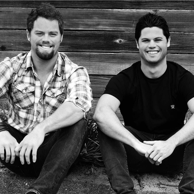 2 men sitting and smiling at camera