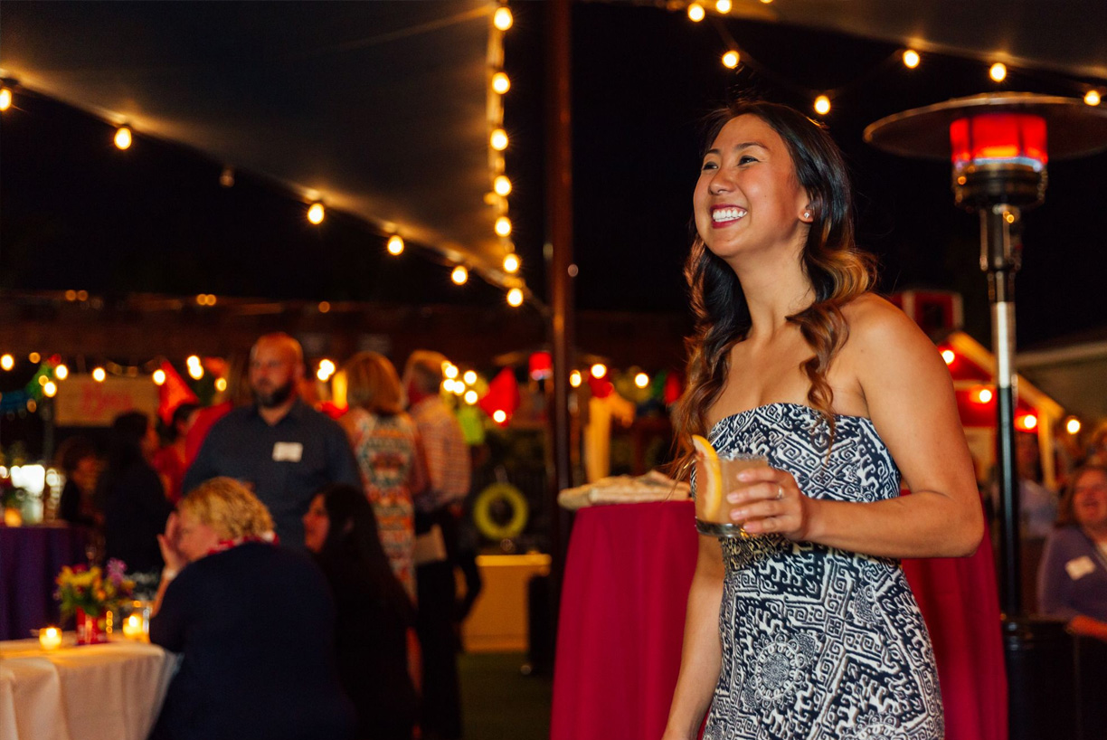 woman smiling holding a drink