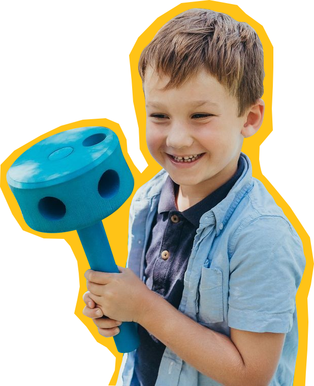 Child at SDCDM playing with a play mallet while smiling at camera