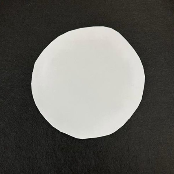 A white circle on black piece of paper.