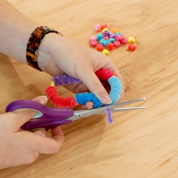 Scissors cutting ends of pipe cleaner.