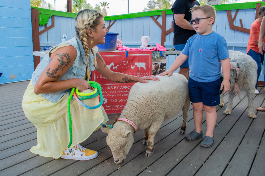 An adult and a child petting a sheep.