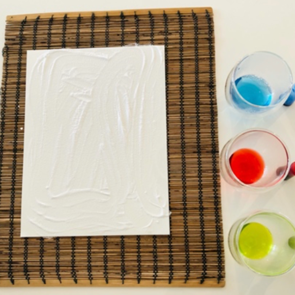 A layer of baking soda on top of the piece of paper.